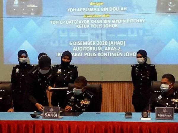 Ayob Khan (tengah) menandatangani buku serah terima tugas sebagai saksi dalam Majlis Serah Terima Tugas Ketua Polis Daerah Batu Pahat, Ketua Polis Daerah Seri Alam, Pengerusi Perkep IPD Batu Pahat dan Pengerusi Perkep Seri Alam di IPK Johor, Johor Bahru, hari ini.