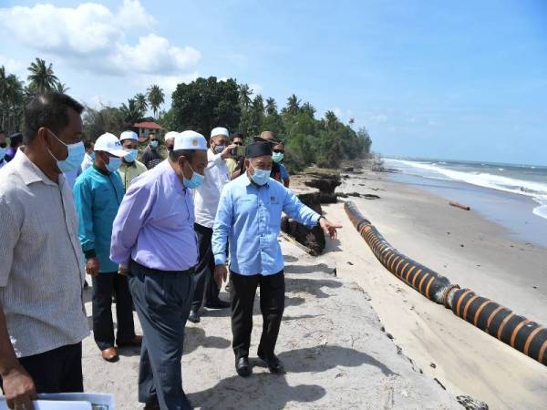 Tuan Ibrahim (kanan) ketika melawat kawasan hakisan di Kampung Pengkalan Maras, Batu Rakit di Kuala Nerus, hari ini.