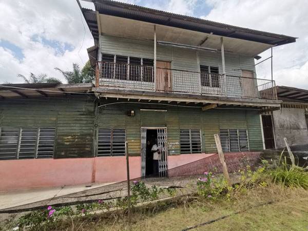 Nor Salim Krishnan dan anaknya berdiri di hadapan rumah mereka di Kampung Kebun Jimah, Port Dickson.