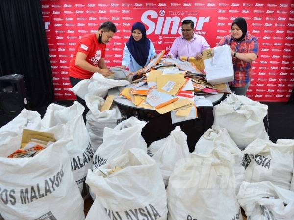 Zamri (dua dari kanan) dan Asmaliza (dua dari kiri) dibantu kakitangan Sinar Harian melakukan pengiraan jumlah penyertaan Peraduan Sinar Harian Di Hatiku di Shah Alam semalam. FOTO: ASRIL ASWANDI SHUKOR