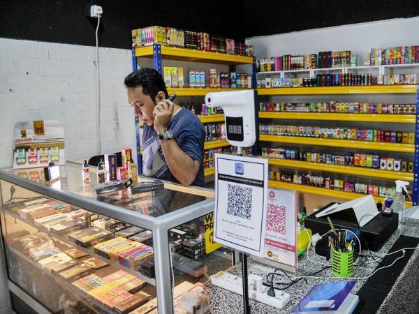 Pemilik Molek Vape Shop Hiekal Rosli melihat barangan cecair atau gel rokok elektronik untuk dijual kepada pelanggan ketika tinjauan hari ini.