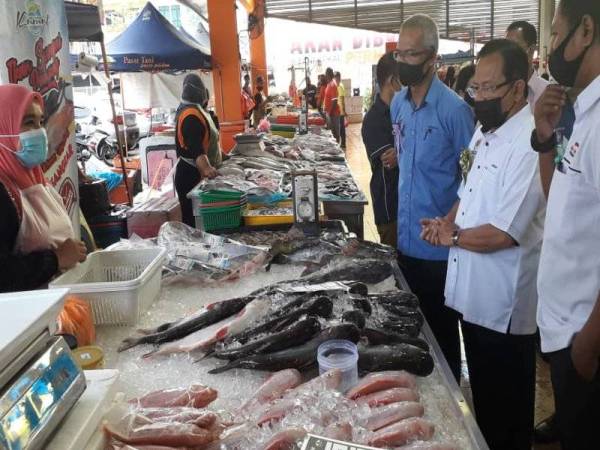 Ahmad (dua dari kanan) meninjau barang keperluan dan bahan basah di PST Permas Jaya, Bandar Baru Permas, Johor Bahru hari ini.