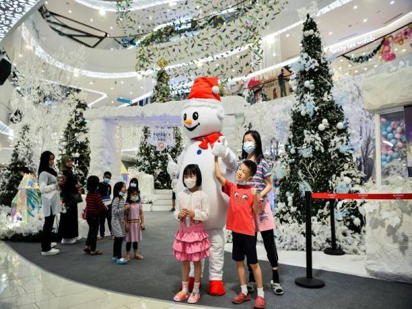 Para pengunjung kelihatan bergambar di sebuah pusat beli-belah yang dihiasi hiasan bertemakan Krismas. Foto Bernama