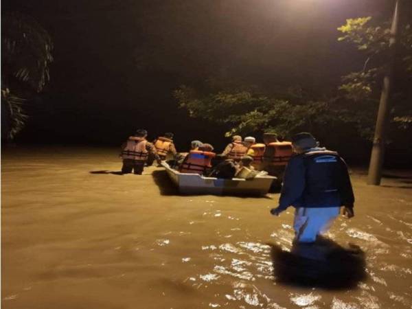 Anggota bomba dari BBP Penawar memindahkan 23 mangsa banjir di Kampung Melayu Raya, Pekan Nanas, Pontian ke PPS di balai raya kampung itu malam tadi.