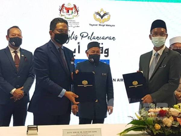 Tuan Ibrahim (tengah) menyaksikan pertukaran MoU antara KASA dan YWM pada Majlis Pelancaran Wakaf Air di Putrajaya.