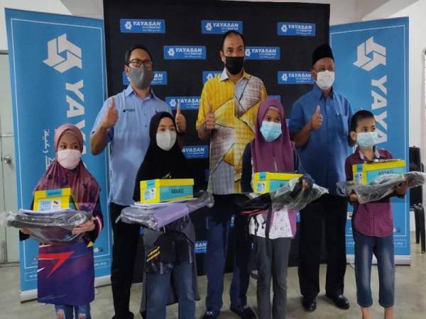 Dari kanan Zakaria, Johan dan Mohd Fauzi bergambar bersama penerima sumbangan YBR di Dewan Orang Ramai Blok N, Pangsapuri Bandar Tasik Kesuma, Semenyih pada Jumaat.