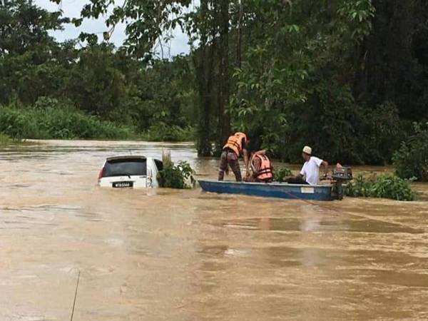 Pihak berkuasa dan penduduk menyelamatkan kenderaan itu daripada tenggelam. Foto: Ihsan pembaca