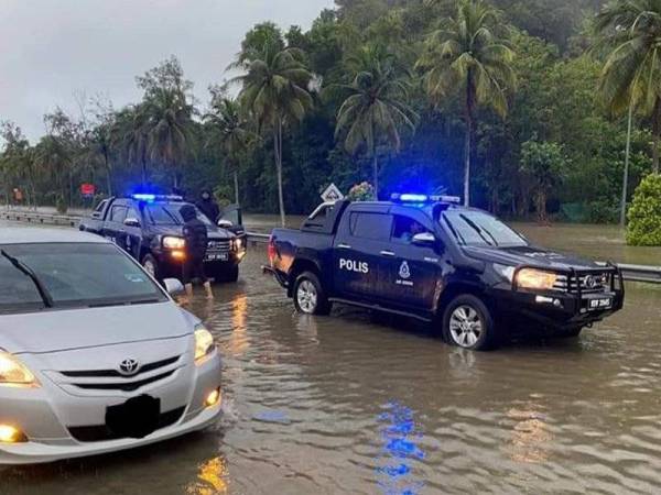 Polis memantau jalan yang dinaiki air di sekitar Kemaman. -Foto ihsan polis