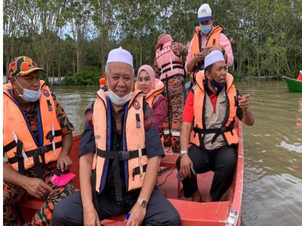 Wan Roslan (kanan) ketika melakukan tinjauan di sekitar Pengkalan Kubor yang ditenggelami air sedalam hampir satu meter hari ini.