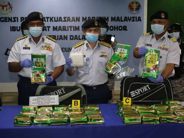 Kamaruszaman (tengah) menunjukkan dadah jenis syabu yang disembunyikan dalam bungkusan teh Cina pada sidang akhbar di Ibu Pejabat Maritim Johor, Johor Bahru pada Selasa.