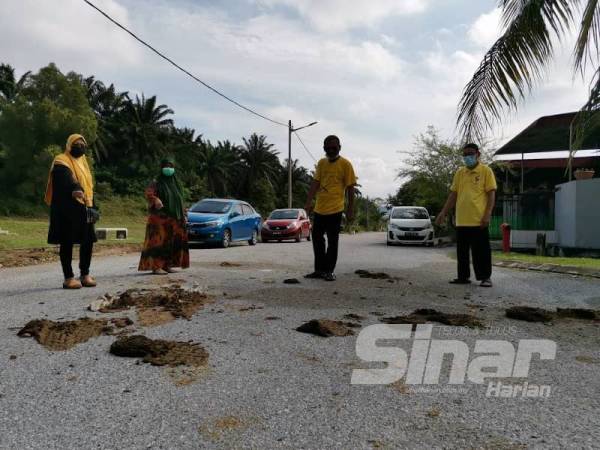 Penduduk menunjukkan najis kerbau yang berlonggok di jalan utama penduduk Margosa, Bandar Seri Botani, Ipoh.