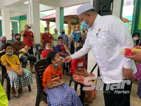 Timbalan Menteri di Jabatan Perdana Menteri (Hal Ehwal Agama), Ahmad Marzuk Shaary menyuap 'pulut semangat' kepada kanak-kanak yang akan berkhatan pada Program Berkhatan Peringkat Pengkalan Chepa di Penambang pada Sabtu.