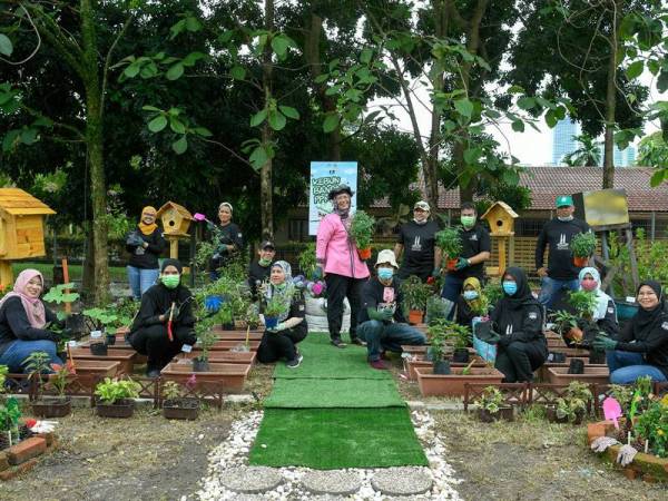 Sheikh Faisal (berdiri, dua dari kanan) bersama kakitangan Pertubuhan Berita Nasional Malaysia (Bernama) bergambar ketika gimik pelancaran Majlis Pelancaran Kebun Bandar Persatuan Pustakawan Malaysia (PPM) dan Little Free Library Sungai Bonus di Kuala Lumpur pada Sabtu. - Foto Bernama
