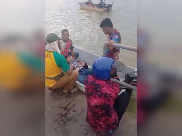 Zunaidee memangku mangsa setelah berjaya diselamatkan selepas terbabit kemalangan di Teluk Intan pada Sabtu. - Foto Ihsan pembaca