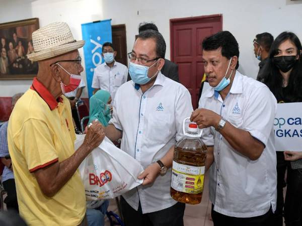 Presiden Angkasa, Datuk Abdul Fattah Abdullah (dua, kiri) menyampaikan sumbangan barangan keperluan harian melalui projek Projek Barang Asas 100 (BA100) kepada salah seorang penerima yang terkesan dengan pandemik Covid-19 pada Program Tanggungjawab Sosial Koperasi (CSR) Coopcare Angkasa di Dewan Persatuan Penduduk Seksyen 1, Wangsa Maju hari ini. - Foto Bernama
