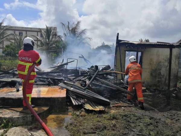 Anggota bomba memadam kebakaran di sebuah rumah di Jalan Tanjung, Endau, Mersing pada Isnin. 