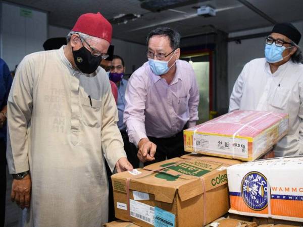 Zulkifli (kiri) mendengar penerangan dari Pengarah Lucky Frozen Sdn Bhd, See Weng Kee (tengah) ketika lawatan kerja di sebuah gudang pembekal dan pengeluar makanan sejuk beku Lucky Frozen Sdn Bhd mengenai isu kartel daging di Segambut pada Isnin. - Foto Bernama