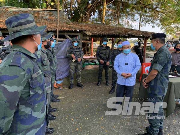 Penolong Pegawai Pemerintah PGA Batalion 7 Kuantan, Deputi Superintendan Ku Majidin Che Ku Jusoh (kanan) memberi penerangan ringkas mengenai pos kawalan kepada Nasurrudin di Pos Sempadan Meranti, Kampung Pak Itam di Pasir Mas.