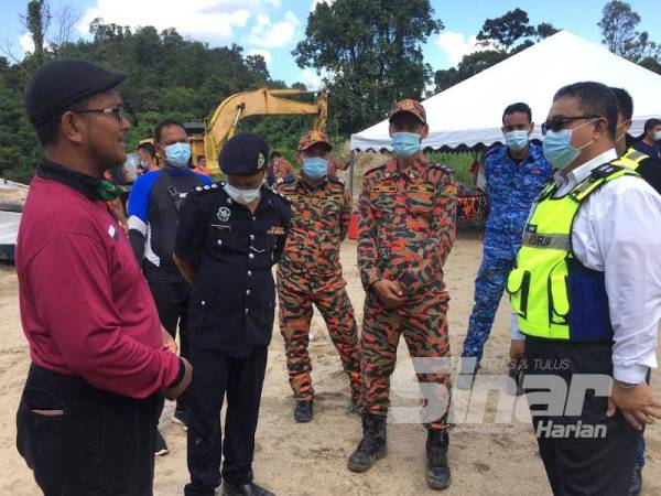 Zaiham (kanan) hadir meninjau operasi SAR mangsa lemas di Sungai Benus di sini yang disambung pagi tadi sebelum mayat mangsa berjaya ditemui.