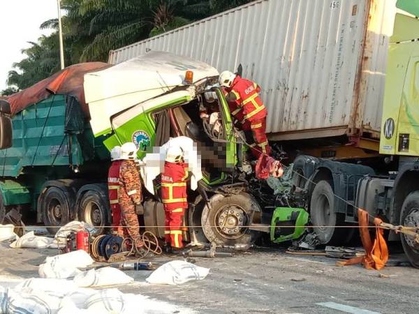 Anggota bomba membantu mengeluarkan mangsa yang tersepit dalam kejadian itu di Kilometer 273.7 Lebuhraya Plus arah Selatan pada Khamis. - Foto Ihsan PDRM