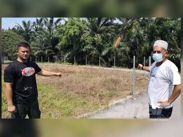 Mohd Norhan (kanan) dan Syahruzzaman (kiri) menunjukkan pagar di Tanah Perkuburan Islam Kampung Simpang 3 Jeram di sini, lesap dikebas pencuri dalam kejadian Rabu.