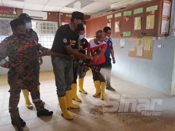 Rosol (tengah) melakukan kerja-kerja pembersihan sewaktu hadir menjayakan Program Gotong Royong dan Penyerahan Sumbangan ‘Food Bank’ di Sekolah Kebangsaan Lubuk Periok, Hulu Terengganu pada Khamis.