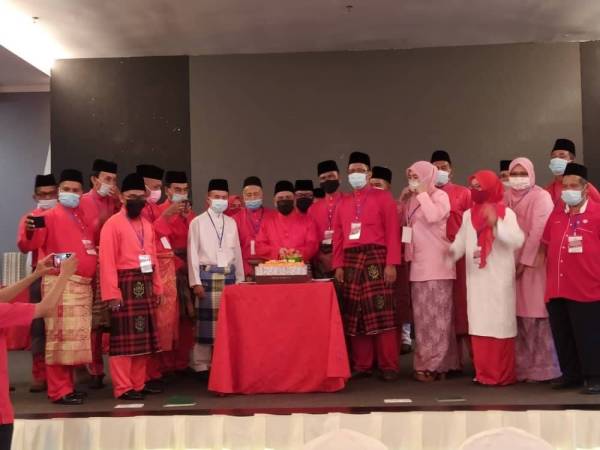 Saarani (tengah) memotong pulut kuning selepas menyampaikan ucapan dasar pada Mesyuarat Perwakilan UMNO Bahagian Larut di sebuah hotel di sini pada Sabtu.
