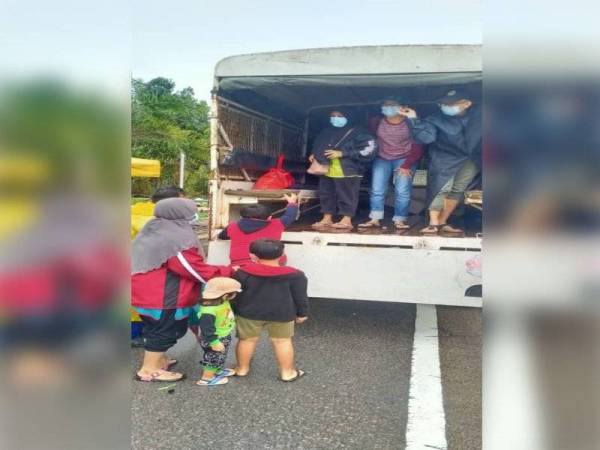 Anggota Angkatan Pertahanan Awam Malaysia membantu penduduk yang terjejas rumah mereka akibat banjir ke pusat pemindahan sementara di Kota Tinggi pada Ahad.