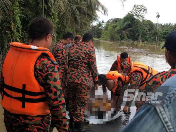 Anggota bomba mengangkat naik mayat penuntut USIM yang lemas di Kampung Bentong, Kluang, pada Isnin.