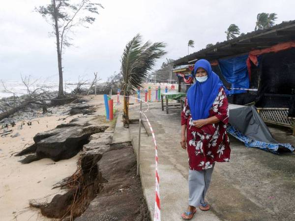 Pemilik kedai makanan, Semek Mamat, 73, meninjau hakisan yang berlaku yang menyebabkan struktur kedainya runtuh ketika tinjauan di Kampung Pengkalan Maras, pada Ahad. - Foto Bernama