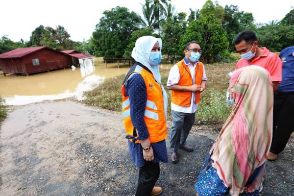 Rina (kiri) bertanyakan sesuatu kepada mangsa banjir ketika meninjau ke daerah Raub pada Isnin