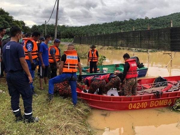 Anggota penyelamat mengangkat mayat mangsa, Md Rajihan Mohd Junaidi, 28, kira-kira pukul 5.15 petang tadi. Mangsa yang dilaporkan hilang pada Sabtu lepas setelah kereta Proton Wira yang dinaiki bersama isterinya, Khairunnisa Ibrahim, 25, dihanyutkan arus banjir di Batu 18, Jalan Kluang-Mersing. - Foto Bernama