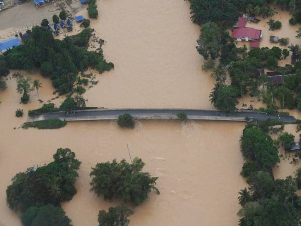 Tenggelam... Jambatan tidak dapat digunakan selepas tenggelami banjir selepas hujan lebat turun lebih tiga hari ketika tinjauan udara bersama Jabatan Bomba dan Penyelamat Malaysia (JBPM) di Lipis pada Isnin. - Foto Bernama