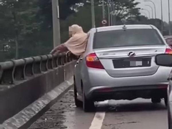 Video berdurasi 20 saat yang menunjukkan seorang wanita membuang plastik dari arah dalam kereta ke jambatan.