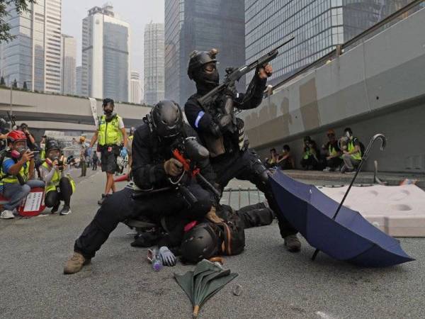 Gambar fail menunjukkan seorang anggota polis menangkap seorang aktivis prodemokrasi Hong Kong. - Foto AFP