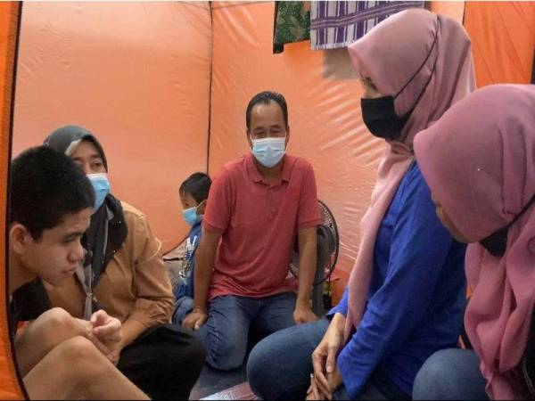 Zahida (dua dari kanan) melawat mangsa-mangsa banjir yang ditempatkan di PPS Dewan Serbaguna Chikus, Langkap pada Khamis.