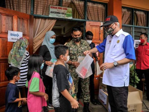 Ismail Sabri Yaakob menyampaikan alat tulis kepada kanak- kanak dan beramah mesra dengan mangsa banjir di Pusat Pemindahan Sementara (PPS) Sekolah Kebangsaan Muhammad Jabar, Raub hari ini. - Foto Bernama