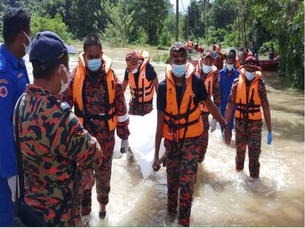 Mayat mangsa dibawa naik ke darat oleh anggota SAR sebelum diserahkan kepada polis untuk tindakan selanjutnya pada Khamis. - Foto Ihsan Bomba Setiu