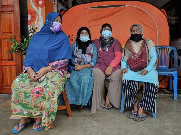 Mangsa banjir Razmah Sarip, 74, (kanan) bersama anak dan cucunya yang terpaksa berpaut di atas sebatang pokok manggis lebih 18 jam selepas rumah mereka di Sungai Kerak, Kuala Gali dinaiki air melepasi paras bumbung rumah ketika ditemu bual bersama wartawan Pertubuhan Berita Nasional Malaysia (Bernama) di Pusat Pemindahan Sementara (PPS) Sekolah Kebangsaan Muhammad Jabar, Raub hari ini.