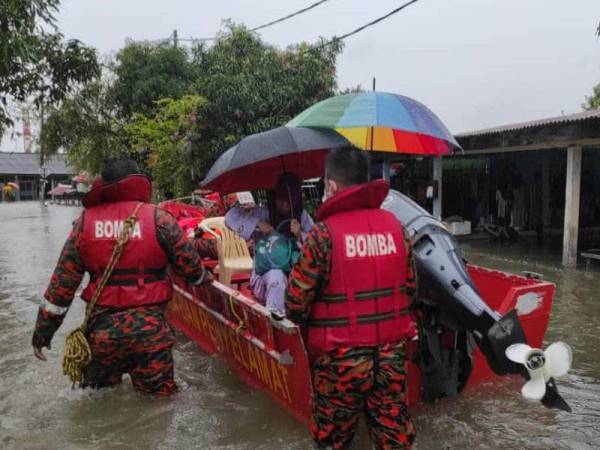 Anggota bomba membantu penduduk yang terjejas akibat banjir di Kampung Sri Jaya, Kota Tinggi iaitu antara penempatan yang masih dinaiki air sehingga Jumaat.