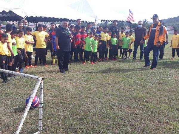 Mahfuz (lima dari kanan) menyepak bola sebagai gimik merasmikan Akademi Bola Sepak Faizal Abu Bakar (FAB) di Taman Bandar Baru, Pokok Sena pada Jumaat.