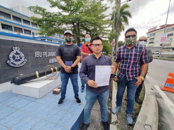 Zulhafizi (tengah) bersama beberapa ahli Gerak Ekonomi Melayu Keramat menunjukkan laporan polis dibuat di Balai Polis Ampang, Kuala Lumpur pada petang Jumaat.