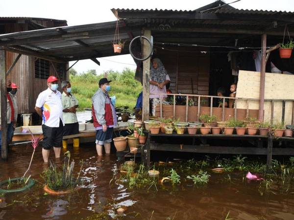 Saifuddin bertanya khabar kepada salah seorang mangsa banjir Norzainah Musfata, 55, di Kampung Chendering, Kuantan pada Sabtu. - Foto Bernama