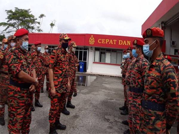 Hamdan (dua dari kiri) memeriksa baris sewaktu membuat lawatan ke Balai Bomba dan Penyelamat Chukai, Kemaman pada Sabtu.