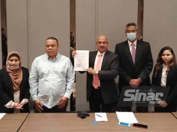 Mohd Haaziq (tiga dari kanan) bersama anak guamnya, Rahman (dua dari kiri) menunjukkan kenyataan akhbar selepas sidang media di sebuah hotel di Petaling Jaya pada Sabtu.