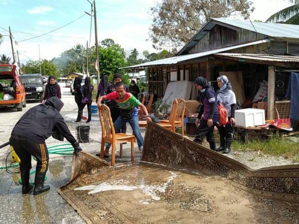 Sukarelawan GPMS membantu membersihkan peralatan rumah mangsa banjir di sekitar Chikus fasa kedua pada Sabtu.