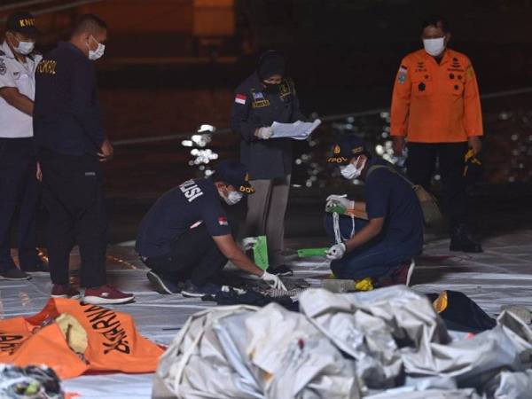 Beberapa lagi serpihan pesawat SJ182 yang ditemui dikumpulkan di pelabuhan Tanjung Priok di utara Jakarta pada Isnin. - Foto AFP