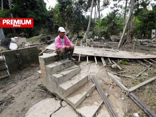 Penduduk Kampung Ajai, Abdul Raof Muntil, 51, termenung mengenangkan nasib apabila rumah yang selama ini menjadi tempat berteduh kini hanya tinggal tangga sahaja kerana dihanyutkan banjir besar. - Foto Bernama