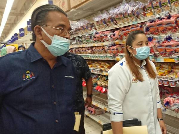 Ismail (kiri) dan Norena melihat stok roti putih yang terdapat di Pasaraya Mydin, Pusat Dagangan Antarabangsa Melaka (MITC) Ayer Keroh, Melaka pada Selasa.