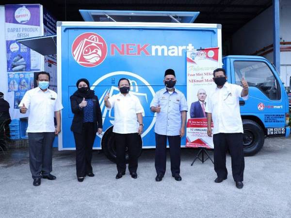 Ahmad (tengah) yang mewakili Ronald menunjukkan isyarat bagus ketika lawatannya di Pasar Mini NEKMart Taman Wahyu pada Selasa.